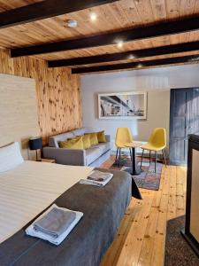 a bedroom with a bed and a couch and a table at Duarto house, Sauna and Hot Tub in Šiaudinė