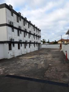 an empty parking lot in front of a white building at Palace Lodge Pinetown in Pinetown