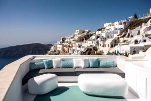 balcone con sedie e cuscini blu e bianchi di Andronikos Santorini a Imerovigli