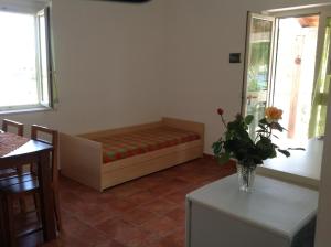 una camera con un divano e un vaso di fiori su un tavolo di Appartamenti Fra Stefano a Peschici