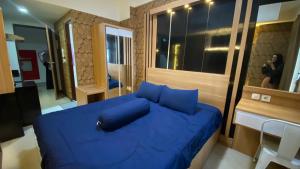 a blue bed with blue pillows in a room at Apartemen Vida View Unit 26H By Millpro in Pampang