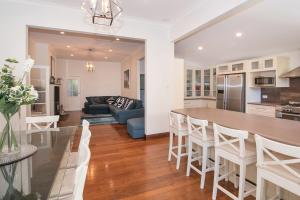 een keuken en woonkamer met een tafel en stoelen bij All Decked Out- WIFI, AC in bedrooms, Fireplace in Busselton