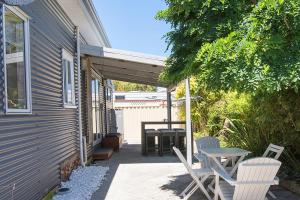 een patio met 2 stoelen en een tafel en een tafel bij All Decked Out- WIFI, AC in bedrooms, Fireplace in Busselton