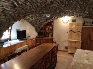 a dining room with a large wooden table and chairs at B&B La Vieille Meison de Pappa in Aosta