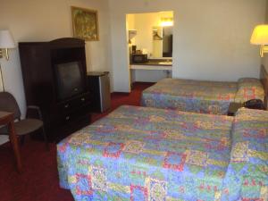 a hotel room with two beds and a television at American Dream Inn in Elk City