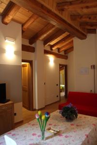 a living room with a table and a red couch at La Barmo Affittacamere in Pietraporzio +9 photos