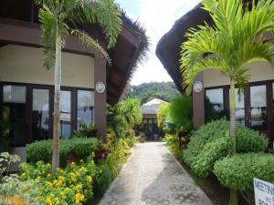 una passerella accanto a un edificio con palme e fiori di Kahuna Beach Resort and Spa a San Juan