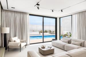 a living room with a couch and a pool at Alrams Retreat in Ras al Khaimah