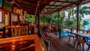 un restaurant avec des tables et des chaises en bois sur une terrasse dans l'établissement Bambuda Lodge, à Bocas del Toro