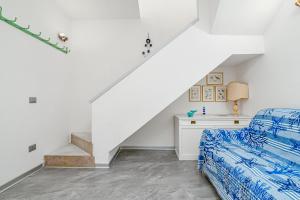 Un dormitorio blanco con una cama y una escalera. en Casa Ferdi, en San Teodoro