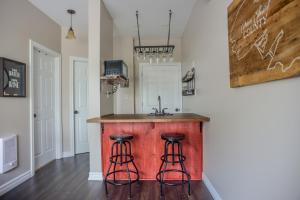 a kitchen with a counter with two stools at The Village Suites in Wellington