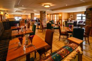 a restaurant with wooden tables and chairs in a room at Cromore Halt in Portstewart