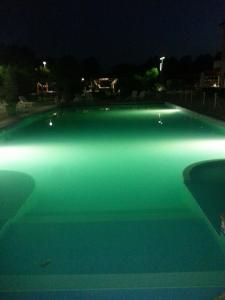 una grande piscina illuminata di notte di Residence Le Fontane a Licciana Nardi
