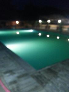 blisko zielonego basenu w nocy w obiekcie Residence Le Fontane w mieście Licciana Nardi
