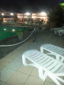 a white bench sitting next to a pool at night at Residence Le Fontane in Licciana Nardi