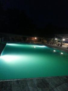 a swimming pool with green illumination at night at Residence Le Fontane in Licciana Nardi