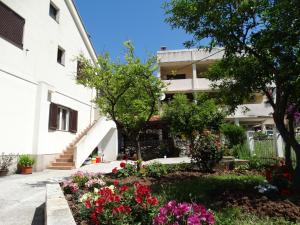 a garden in front of a building with flowers at Apartments Ilinka in Budva