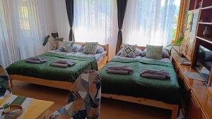 a bedroom with two beds with pillows on them at Родопско сърце in Chepelare