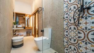 a bathroom with a toilet and a shower at Taman Kencana Ubud in Ubud