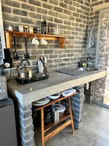 a kitchen with a counter and a brick wall at Northern Rock Accommodation in Otjiwarongo +21 photos