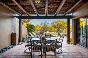 Un patio con una mesa y sillas en un patio. en Exclusive Boulders Retreat near Downtown Cave Creek hiking scenic views., en Cave Creek