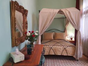 ラバトにあるRiad Dar Karimaのベッドルーム1室(鏡付きベッド1台、テーブル付)
