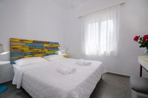 Un dormitorio con una cama blanca con toallas. en Kallimento, en Kissamos