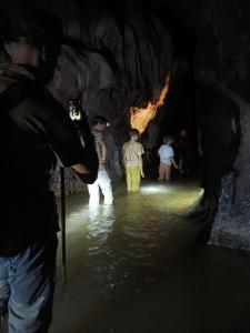 TimbanglawangBatu Katak - Zoey's Homestay的一名男子正在给一群在洞穴里的人拍照