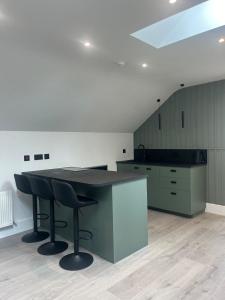 a large kitchen with a black counter and a table at The Loft in Clonmore