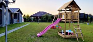 a playground with a slide in a yard at Szalona Gęś in Gąski