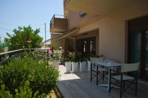 a balcony with a table and chairs on a building at Aloe Apartments Ammouliani in Ammouliani