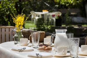 a table with a white table cloth with eggs and milk at Kantouni Apartments in Svoronata