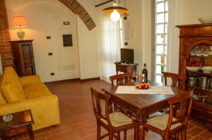 a living room with a table and a couch at Adalberto - nella dimora di Fulignano in San Gimignano