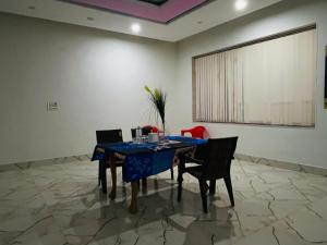 a dining room with a blue table and chairs at Hotel & Resort Virasat inn in Alwar