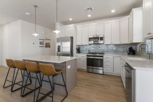 een keuken met witte kasten en een eiland met barkrukken bij St, Gorgeous condo in Atkinville