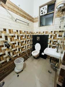 a bathroom with a toilet and a sink and a clock at Hotel & Resort Virasat inn in Alwar +43 photos