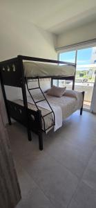 1 Schlafzimmer mit 2 Etagenbetten und einem großen Fenster in der Unterkunft Bluu Habitat Lagoons En Mazatlan DEPARTAMENTO in Mazatlán + 3 Fotos