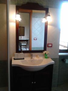 a bathroom with a sink and a large mirror at Affittacamere La Vigna in Serramezzana