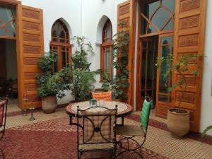 un patio con mesa, sillas y plantas en Riad Dar Karima en Rabat