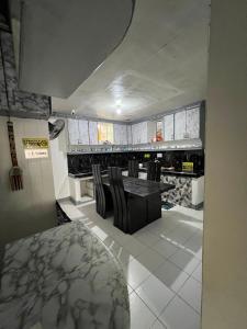a kitchen with a table and chairs in a room at Ibañez Residence near airport sm roxas city in Roxas City +11 photos