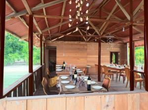 a dining room with a table and chairs on a deck at Rima Homestay in Kri