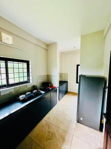 a large kitchen with black cabinets and a window at Malabar Service Apartments in Cochin