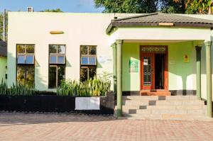 a building with a red door and some plants at ROYAL SHALOM HOTEL in Lusaka