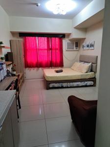 a bedroom with two beds and a red window at Studio Condo Horizon Condominium in Cebu City