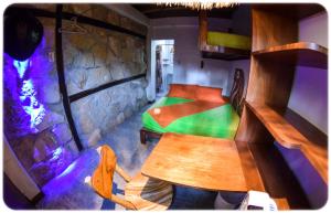 Habitación con mesa, cama y pared de piedra. en Hostal Oloncito, en Olón