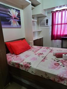 a bedroom with a bed with a red pillow at Studio Condo Horizon Condominium in Cebu City