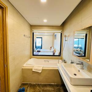a bathroom with a tub and a sink and a mirror at FLC Sea Tower Seaview Quy Nhon in Quy Nhon