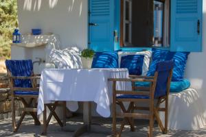 ステリダにあるspitakia naxosの青いドア付きのポーチにテーブルと椅子
