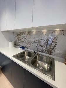 a stainless steel sink in a white kitchen at Noema Apartment 5 Maji - A Cosy Stay in Tirana in Tirana +8 photos