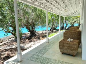 a porch with chairs and a view of the water at The Serai Inar in Pulau Landu